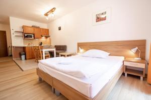 a bedroom with a large bed and a kitchen at Fatrapark 2 Apartments House in Ružomberok