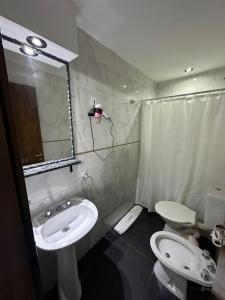 a bathroom with a sink and a toilet and a mirror at Hotel Quito in Buenos Aires +18 photos