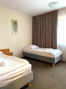 um quarto de hotel com duas camas e uma janela em CKS Warszawa (Centrum Konferencyjno-Szkoleniowe CS Natura Tour) em Varsóvia