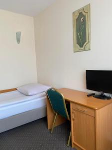 a room with a bed and a desk with a television at CKS Warszawa (Centrum Konferencyjno-Szkoleniowe CS Natura Tour) in Warsaw