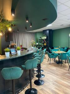 a bar with green chairs and tables in a restaurant at CKS Warszawa (Centrum Konferencyjno-Szkoleniowe CS Natura Tour) in Warsaw