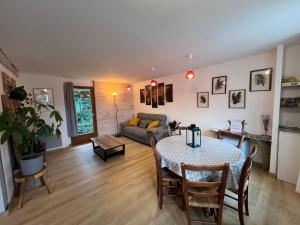 een woonkamer met een tafel en een bank bij Le petit Chalet 5 min de Beauval in Saint-Aignan