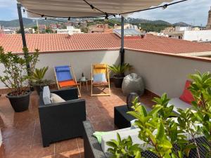 un patio con sillas y una sombrilla en el techo en RCE Apartments Calella, brand new next to the beach., en Calella