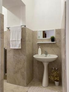 een badkamer met een witte wastafel en een spiegel bij I Cento Portali - Albergo Diffuso in Pignola