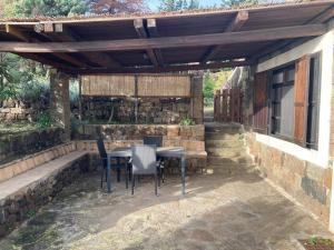 a patio with a table and chairs under a wooden pergola at il patio mini appartamento in Pantelleria +9 photos