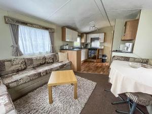 ein Wohnzimmer mit einem Sofa und einem Tisch in der Unterkunft Great Caravan At Breydon Water Holiday Park, Ref 10086b in Belton