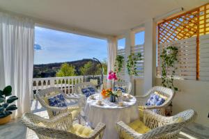 ein Esszimmer mit einem Tisch und Stühlen auf einer Veranda in der Unterkunft Casa Memory in Crikvenica