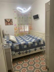 1 dormitorio con 1 cama con manta azul y blanca en Casa delle farfalle, en Pontinvrea