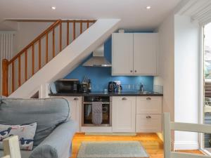 a living room with a kitchen under a staircase at Topsail in Dartmouth
