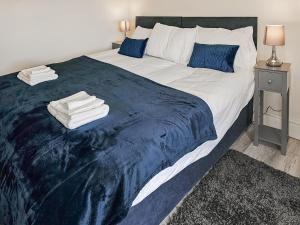 a bedroom with a large bed with towels on it at Queen House in Belper