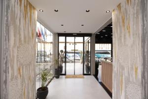 un pasillo de un edificio con puertas y plantas de cristal en Residence Inn Hotel en Tirana