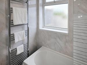 een badkamer met een witte wastafel en een raam bij Queen House in Belper
