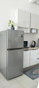 a stainless steel refrigerator in a kitchen with white cabinets at Camelia youth city nilai studio residence 5 pax. in Nilai