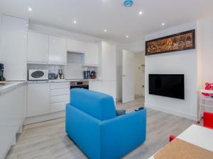 a blue chair in a living room with a kitchen at No, 2 - Uk46743 in Cromer