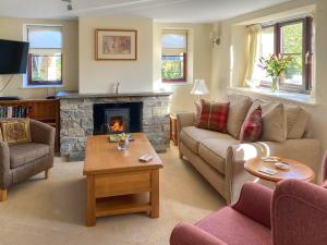 a living room with a couch and a fireplace at The Old Haybarn in Long Sutton