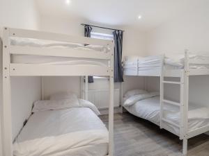 two bunk beds in a room with white walls at No, 2 - Uk46743 in Cromer