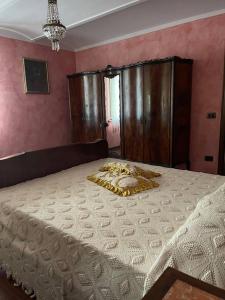 a large bed in a bedroom with pink walls at La Cassina: accogliente appartamento in campagna in Spilamberto