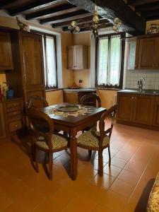 a kitchen with a wooden table with chairs and a sink at La Cassina: accogliente appartamento in campagna in Spilamberto