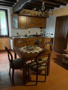 - une cuisine avec une table en bois, des chaises et un évier dans l'établissement La Cassina: accogliente appartamento in campagna, à Spilamberto