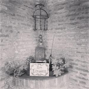 a black and white photo of a wall with a clock and flowers at La Cassina: accogliente appartamento in campagna in Spilamberto