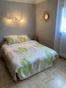 Cases-de-PèneにあるAppartement spacieuxのベッドルーム1室(ヤシの葉が生えた白い掛け布団付きのベッド1台付)