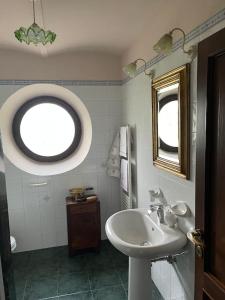 La salle de bains est pourvue d'un lavabo et d'une fenêtre. dans l'établissement La Cassina: accogliente appartamento in campagna, à Spilamberto