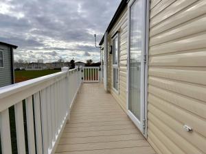 a wooden walkway next to a house at Great Caravan With Wifi And Decking At Dovercourt Holiday Park Ref 44006c in Great Oakley
