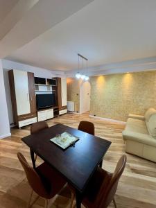 salon ze stołem i kanapą w obiekcie Cozy Apartment w mieście Zalău