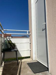 una puerta a un balcón con una mesa al lado en Appartement T2 proche de la gare Bourg en Bresse, en Bourg-en-Bresse