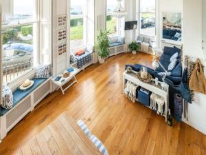 un soggiorno con divano blu e pavimenti in legno di The Little Beach House a Brighton & Hove