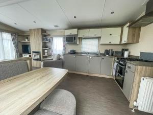 a kitchen with a long wooden table in a room at Modern 6 Berth Caravan With Free Wifi Nearby Pakefield Beach Ref 68028cr in Lowestoft