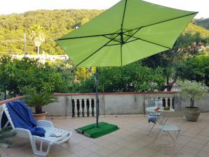 un ombrellone verde seduto in cima a un patio di villa laria a Tropea