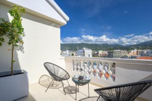 a balcony with two chairs and a table at Balcony Luxury Apartment Kalamata in Kalamata