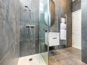 a bathroom with a shower with a glass door at The Old Chapel in Saint Columb Minor