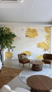 una sala de estar con sillas y una pared con un mural floral en Hotel Golden en Rímini