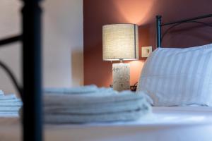 a lamp sitting on top of a bed next to a pillow at Tenuta Cantona in Casole dʼElsa