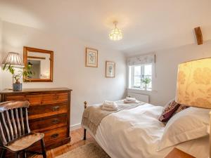 a bedroom with a bed and a dresser and a mirror at Swallow Cottages, No 1 - Uk46811 in Thurgarton