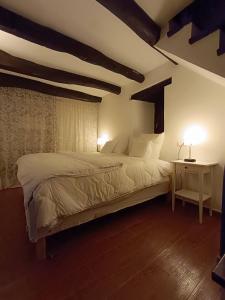 um quarto com uma cama e uma mesa com um candeeiro em small House of La Reguera 