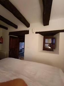 um quarto com uma cama branca e 2 janelas em small House of La Reguera 