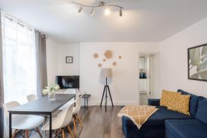 a living room with a blue couch and a table at Gloucester Place/Marylebone Apartments in London