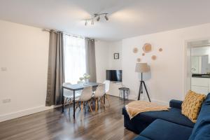 a living room with a blue couch and a table at Gloucester Place/Marylebone Apartments in London