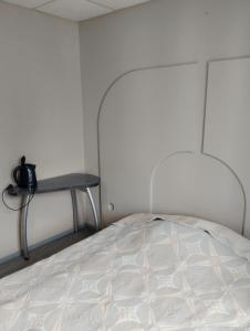 a white bed in a room with a table at Apartments Londa in Jūrmala