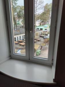 een open raam met uitzicht op een tuin bij Apartments Londa in Jūrmala