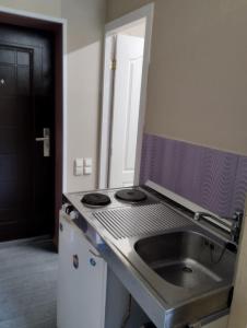 a kitchen with a sink and a stove at Apartments Londa in Jūrmala