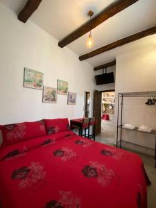 een slaapkamer met een rood bed en een tafel bij I Cento Portali - Albergo Diffuso in Pignola