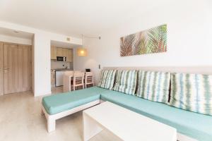 a living room with a couch and a kitchen at Palm Garden in Port d'Alcudia
