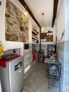 eine Küche mit einem Kühlschrank und einem Tisch im Zimmer in der Unterkunft I Cento Portali - Albergo Diffuso in Pignola