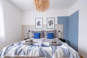 a bedroom with a large bed with blue pillows at 30m zum Meer, Privatparkplatz, Balkon, Netflix in Medulin