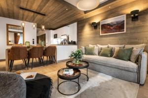 un soggiorno con divano e tavolo di Falcon Lodge by Alpine Residences a Méribel