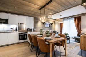 eine Küche und ein Esszimmer mit einem Tisch und Stühlen in der Unterkunft Falcon Lodge by Alpine Residences in Méribel